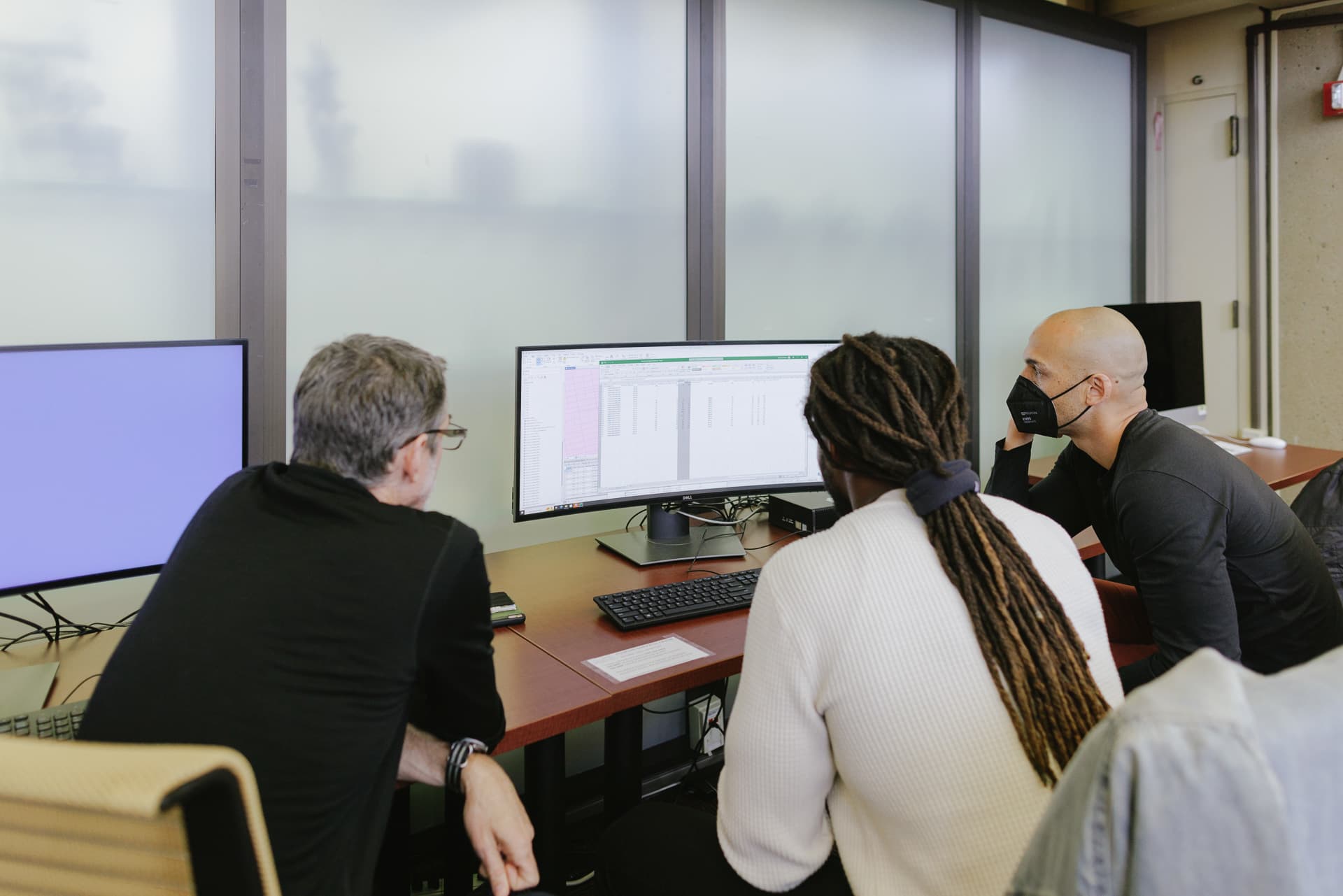 Staff and students working on data on computer